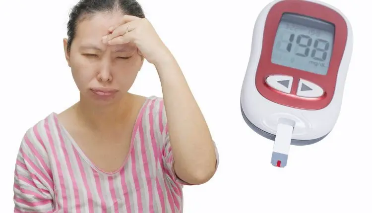 صورة بها سيدة عليها على وجهها علامات الاستياء بسبب إصابتها بالسكر وبجوارها جهاز قياس نسبة السكر