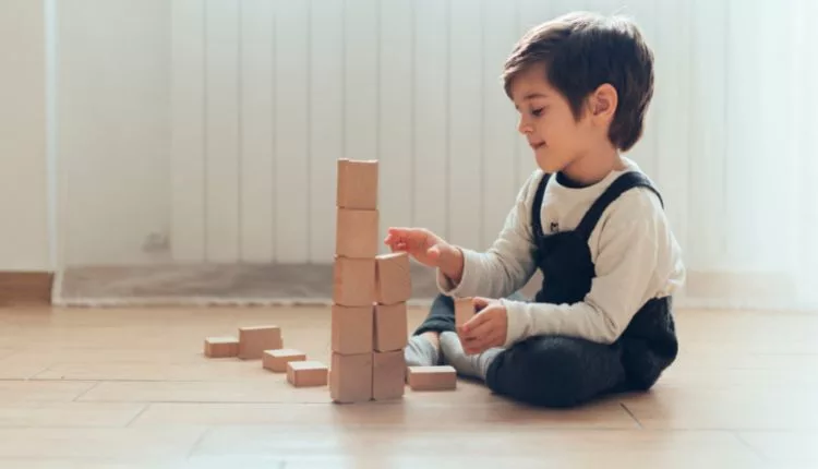 صوره لطفل يلعب بالالعاب علي الأرض تعبيرًا عن هل يتم الشفاء من فرط الحركة للاطفال