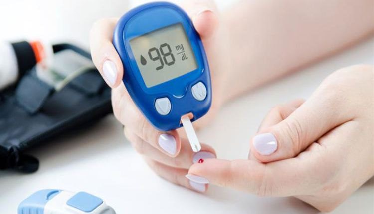 صورة ليد امرأة تجري اختبار السكر باستخدام جهاز قياس نسبة السكر في الدم 